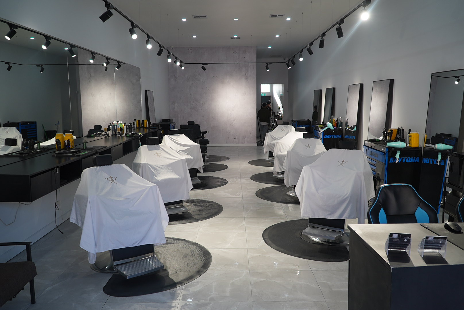 Empire Barbershop interior — eight barber chairs draped with white Empire capes, ready for the next appointment