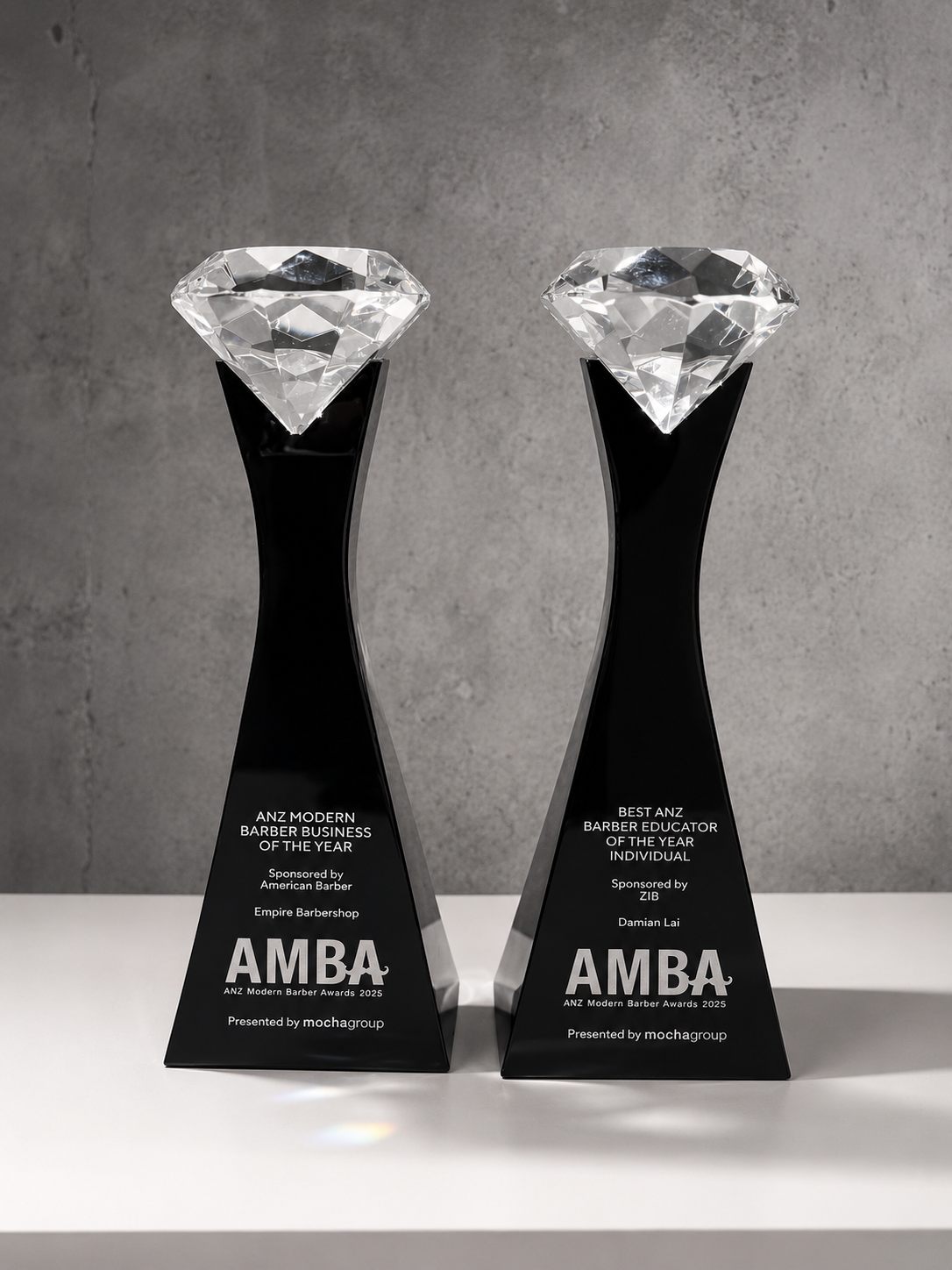 The two 2025 AMBA trophies — ANZ Modern Barber Business of the Year (Empire Barbershop) and Best ANZ Barber Educator of the Year Individual (Damian Lai)